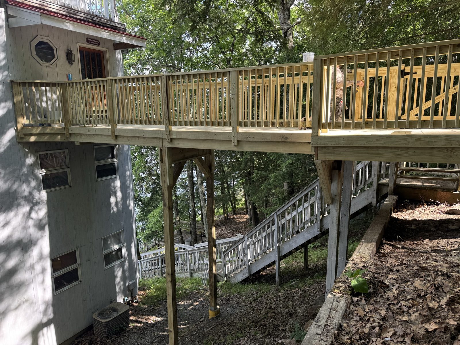 Finished elevated lakeside deck with new pressure-treated railing connecting to the cottage