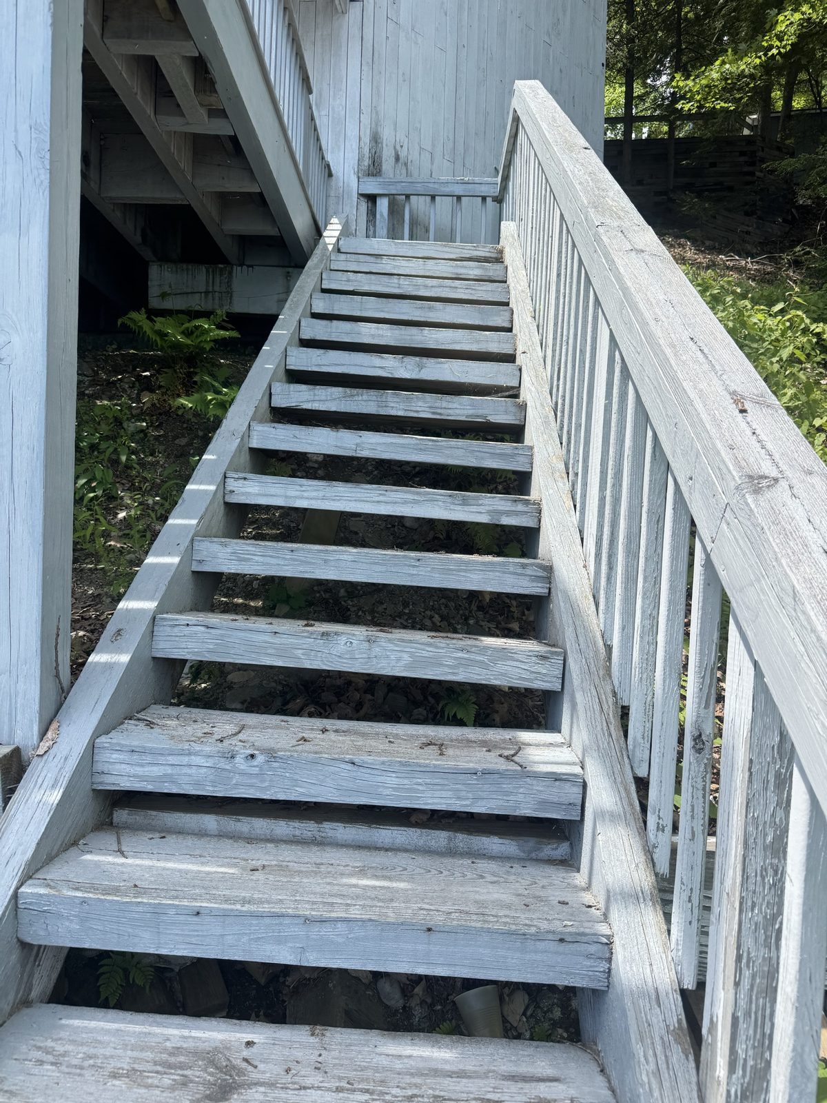 Old weathered gray staircase leading down to the lake before replacement