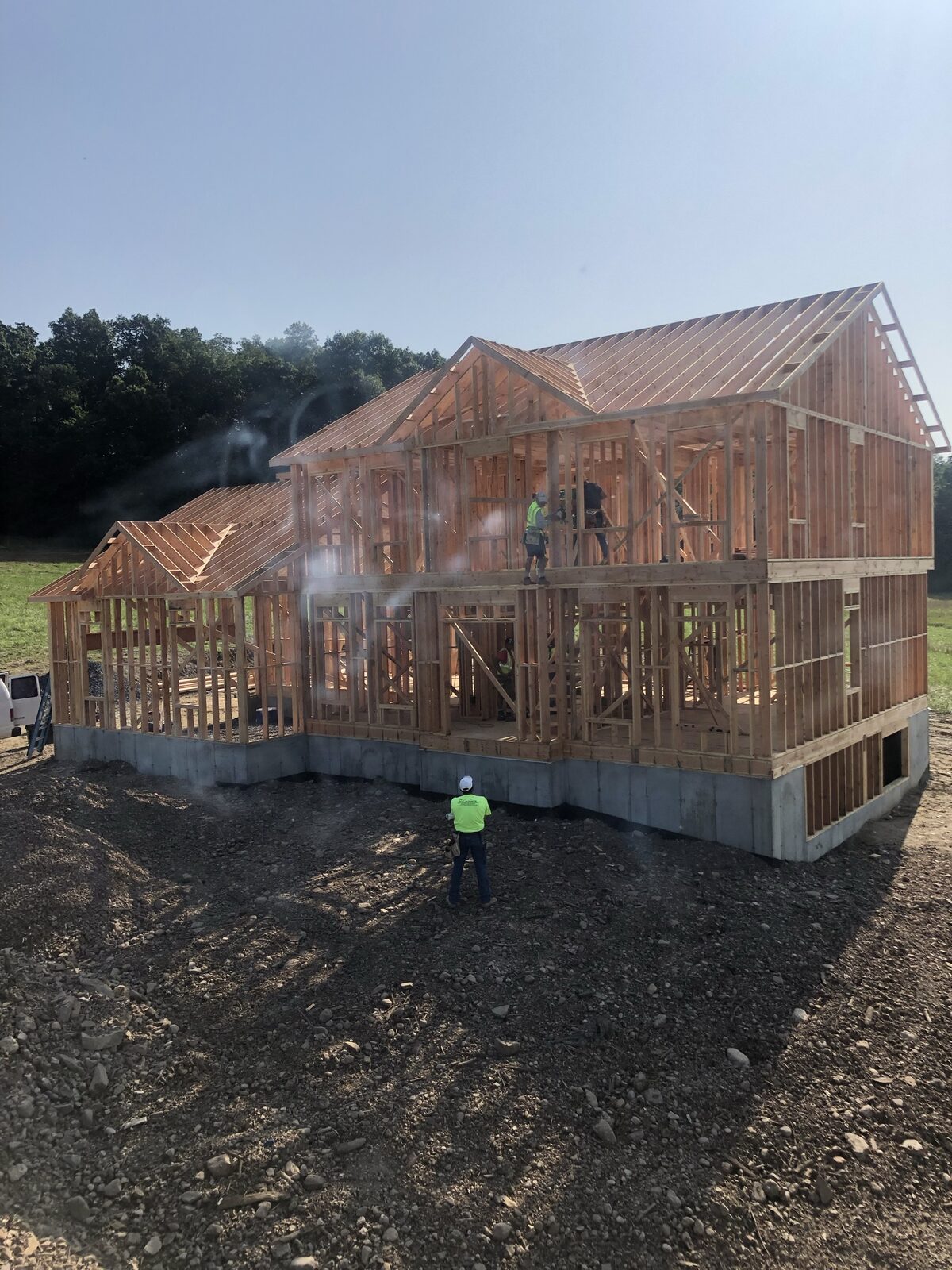 Wilson's crew framing a two-story custom home with steam rising off fresh lumber