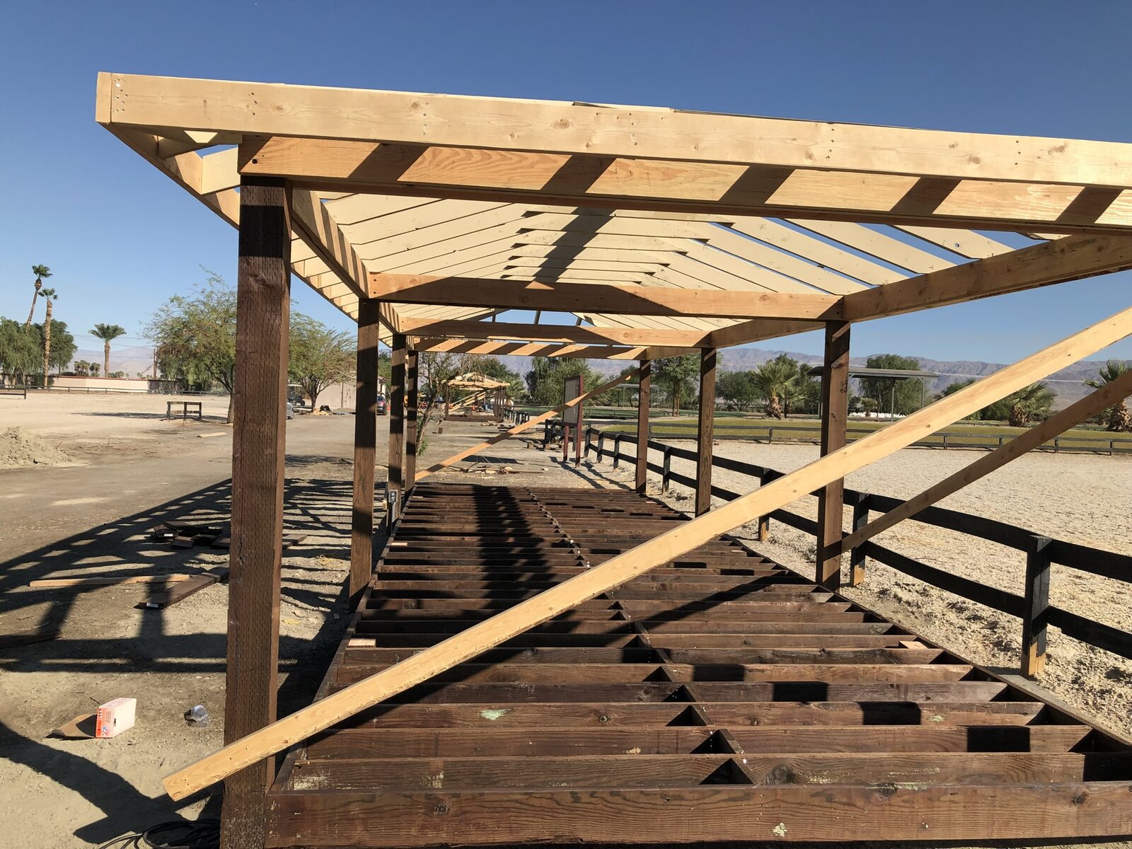 Custom timber pergola shade structure with canvas shade sail over a paver patio