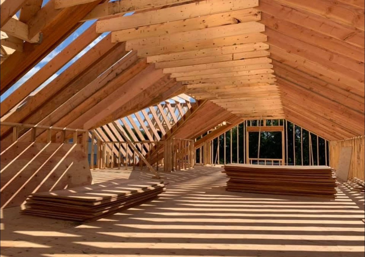 Detailed view of vaulted roof rafters and ridge beam framing with afternoon light